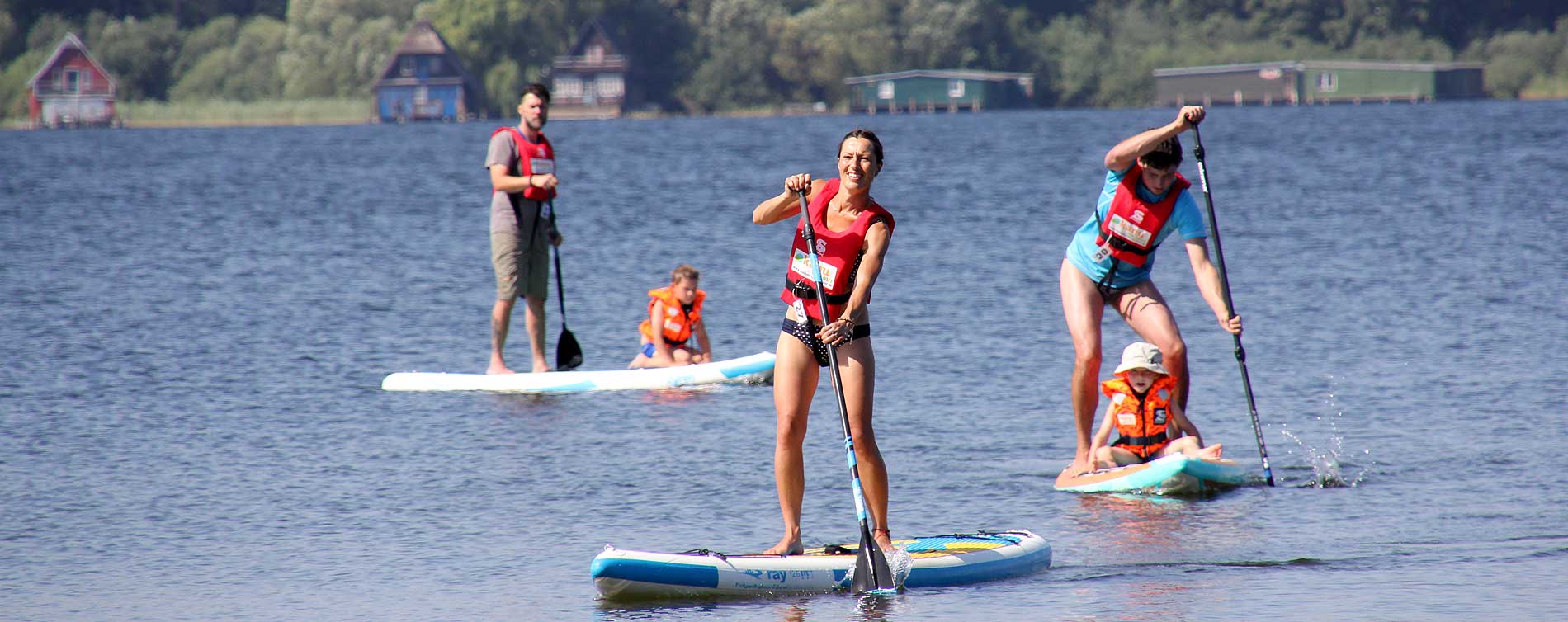 Foto Divserse Personen mit SUPs auf dem See